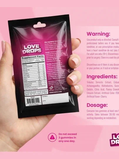 Hand holding a 'Love Drops' supplement package with pink background and product details.
