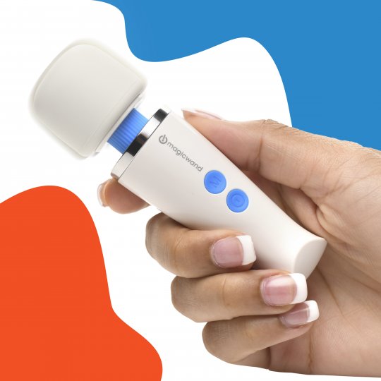 Hand holding a white electronic device with blue buttons against a blue and orange background