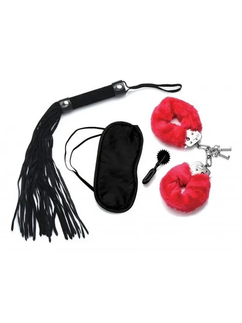 Set of black leather whip, black eye mask, red hair scrunchies with keys, and black brush on a white background