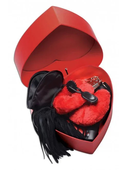 Red heart-shaped box with black leather glove and red heart-shaped object on a white background