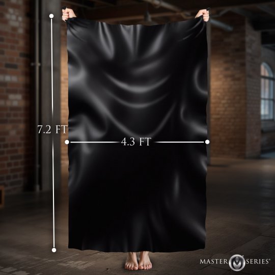 Black satin fabric draped over a person with measurements in feet, set against a brick wall background.