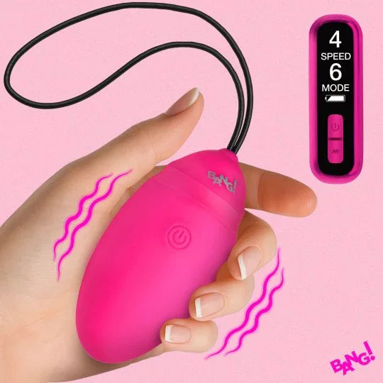 Pink electronic device with digital display and hand holding it on a pink background